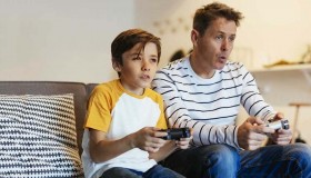 research-frames-gamers-father-and-son-playing-video-game-on-couch-at-home